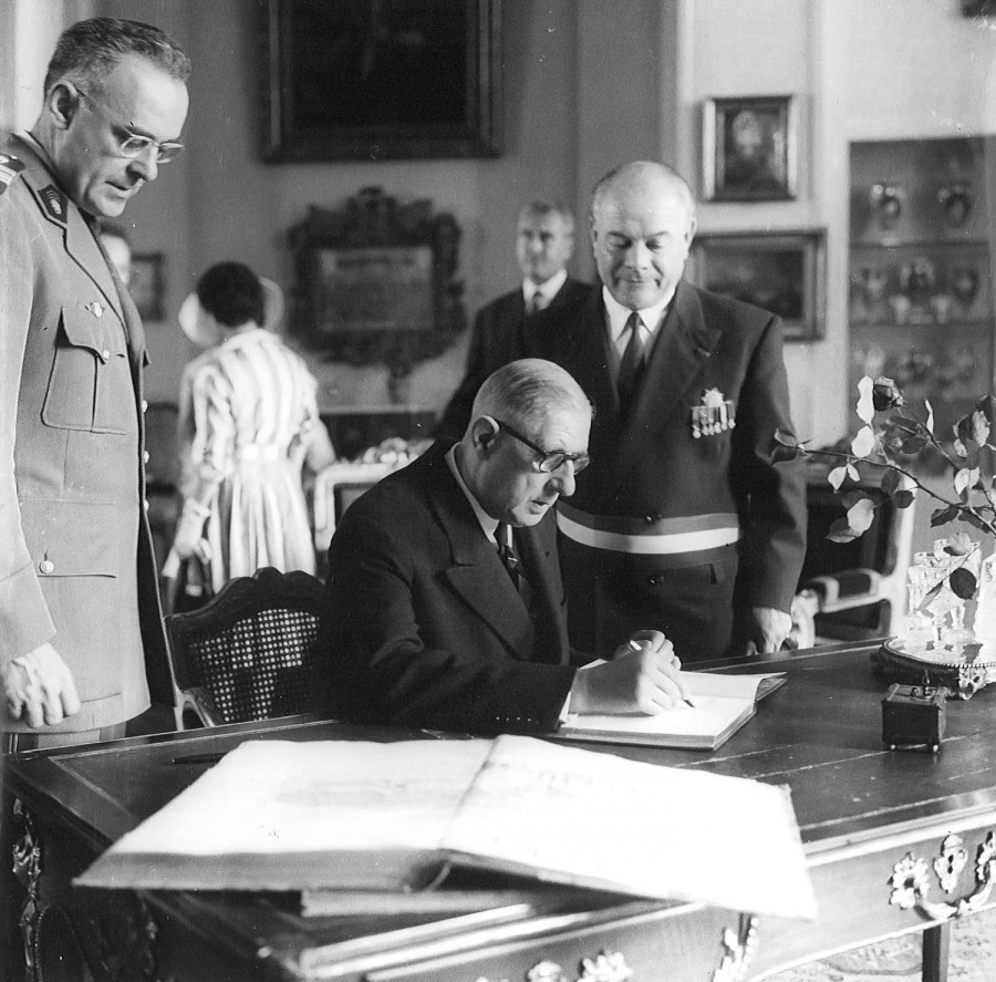 Le Général de Gaulle signant le livre d'or de la Ville de Blois. À sa gauche Marcel Bühler, maire de Blois (Musée des Beaux Arts de Blois)
